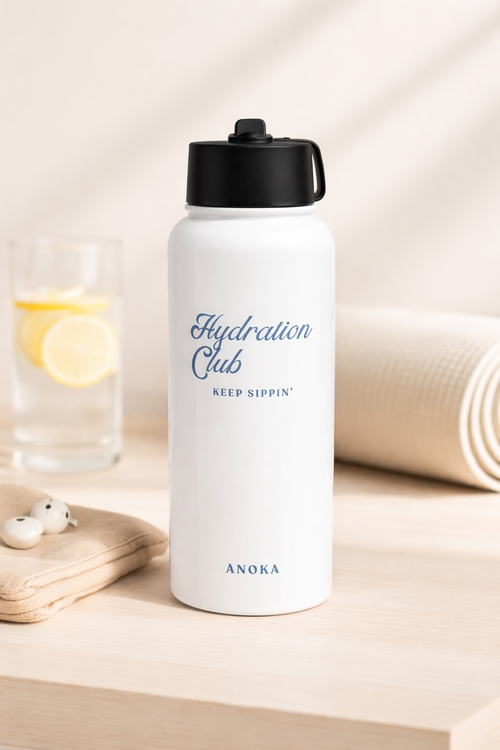 White water bottle with black lid labeled 'Hydration Club' on a light surface.